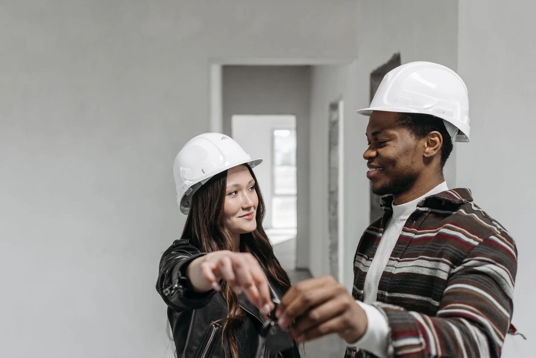 jeune couple primo-accédant devant une maison neuve conforme RE2020